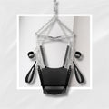 Black leather harness with chains on a light gray background