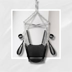 Black leather harness with chains on a light gray background