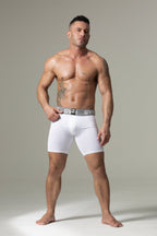 Man wearing white boxer briefs against a neutral background