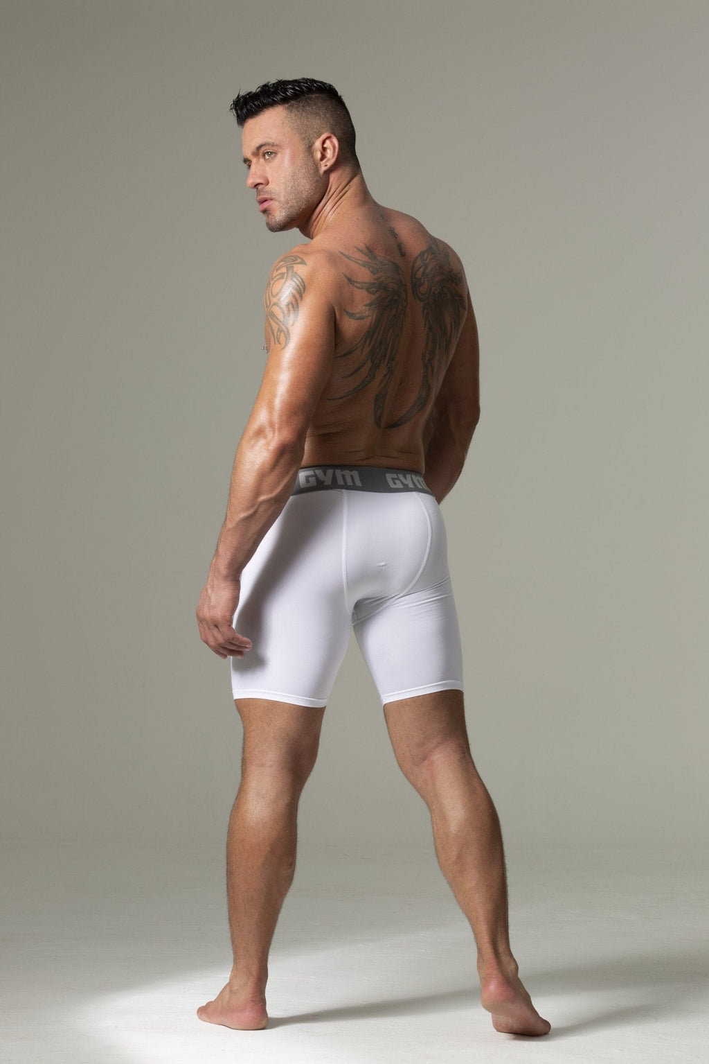 Man wearing white boxer briefs against a neutral background