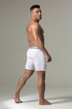 Man wearing white boxer briefs with a brand logo on a neutral background