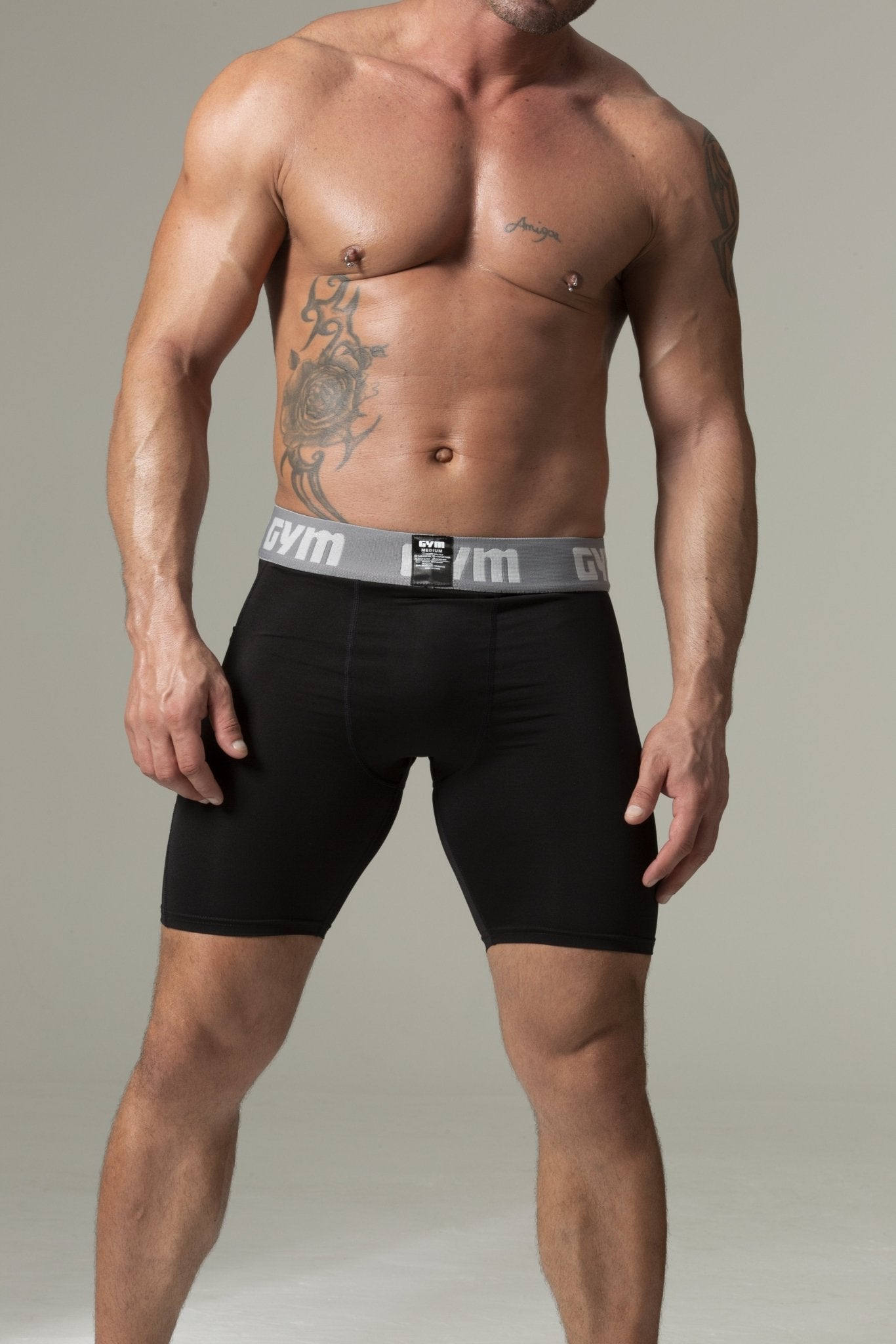Man wearing black boxer briefs with a gray waistband on a neutral background